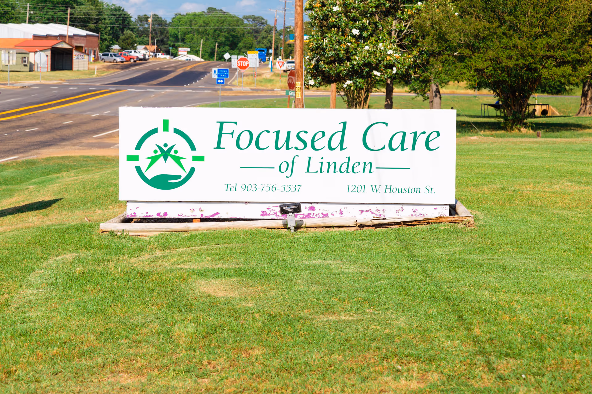 A lawn-mounted roadside sign reading "Focused Care of Linden" on a grassy lot beside a road.