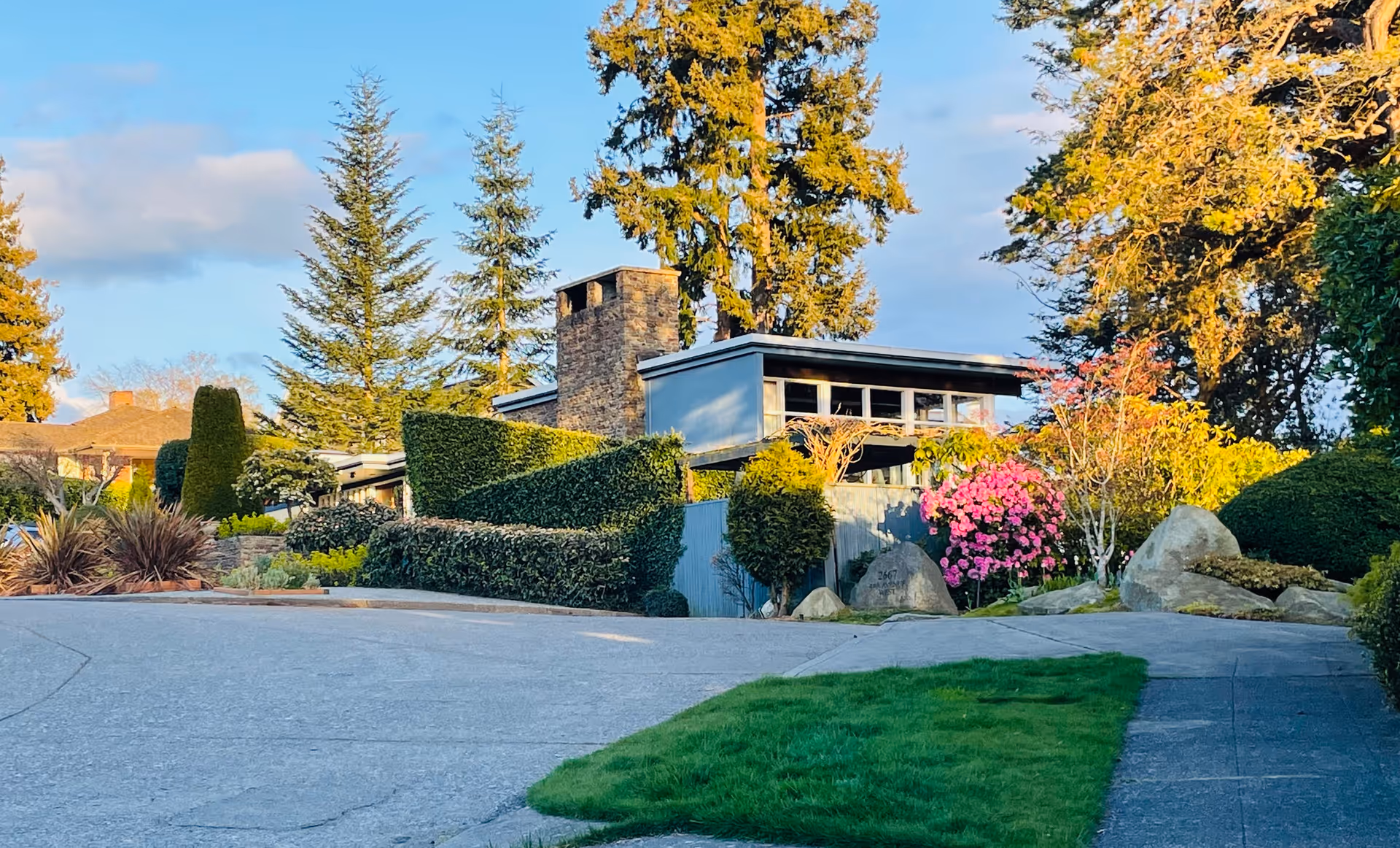 Front exterior of Carlton Park Adult Family Home LLC, a single-story building with manicured lawns and colorful landscaping.