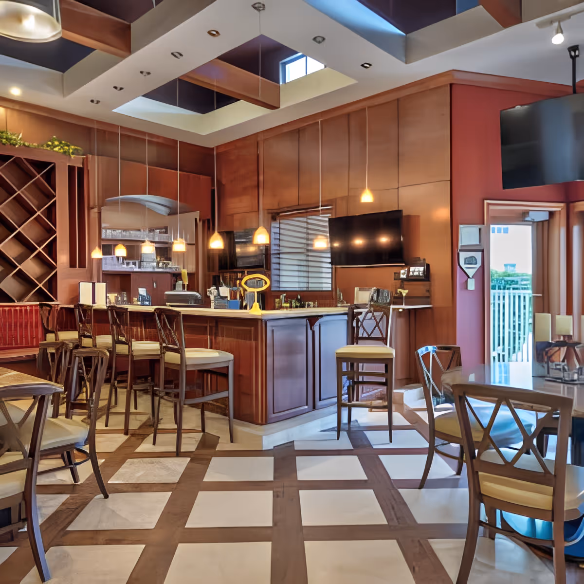 A warm, wood-paneled dining/lounge interior showing a central bar with stools, pendant lights, seating tables, and mounted TVs.