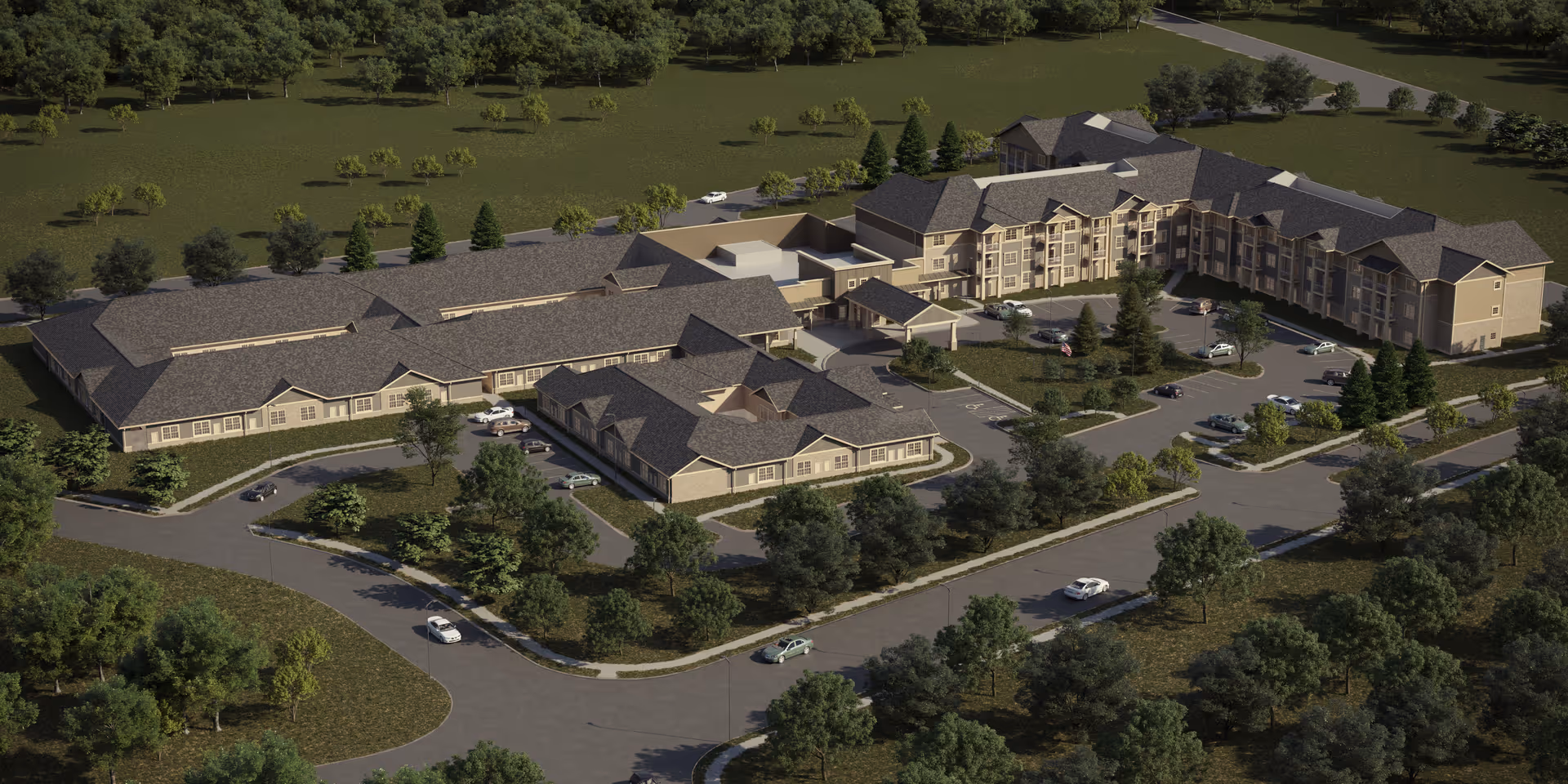 Aerial view of a large senior living complex with multiple connected buildings, parking areas, driveways, and surrounding trees.
