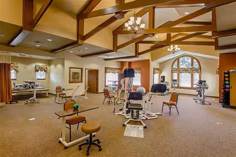 Senior fitness room at Hollymead with exercise machines and wooden beams.