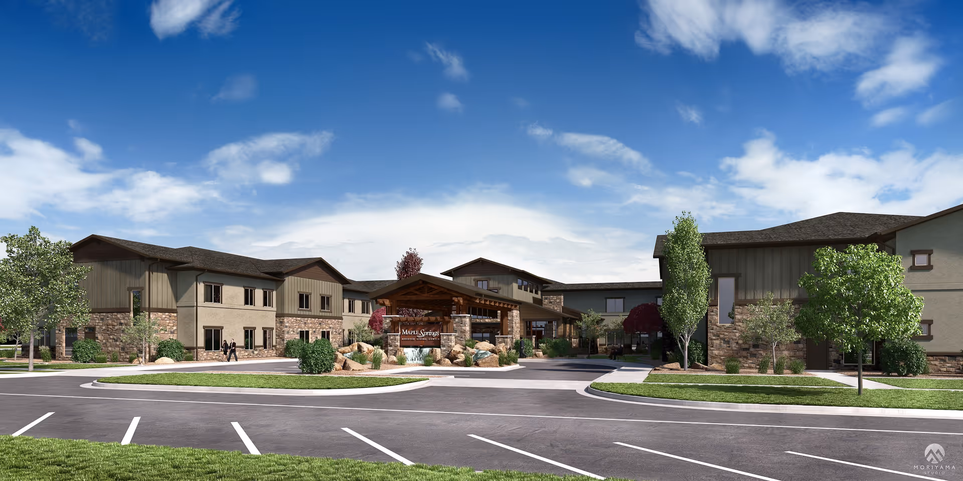 Front exterior of a two-story senior living facility with a covered main entrance, landscaped roundabout, and parking under a blue sky.