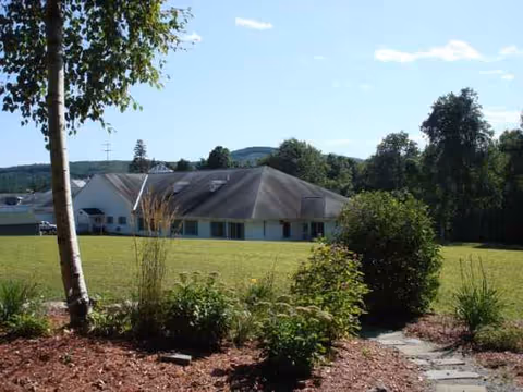 Exterior view of a single-story nursing home with a manicured lawn.