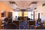 Bright senior living lounge with chairs arranged facing a front wall.