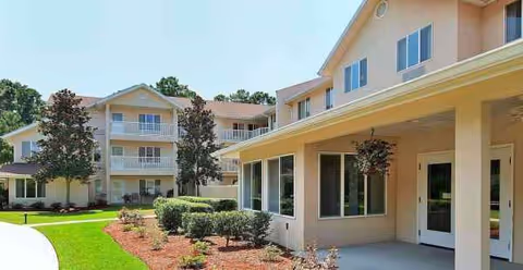 Exterior view of Cherry Laurel - Sky Active Living with entryway and landscaped lawn.