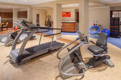 Indoor fitness room with treadmills and stationary bikes in a senior rehab facility.