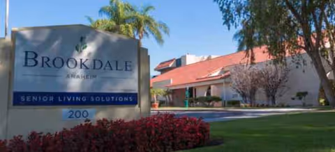 Brookdale Anaheim senior living entrance sign with landscaping and palm trees.