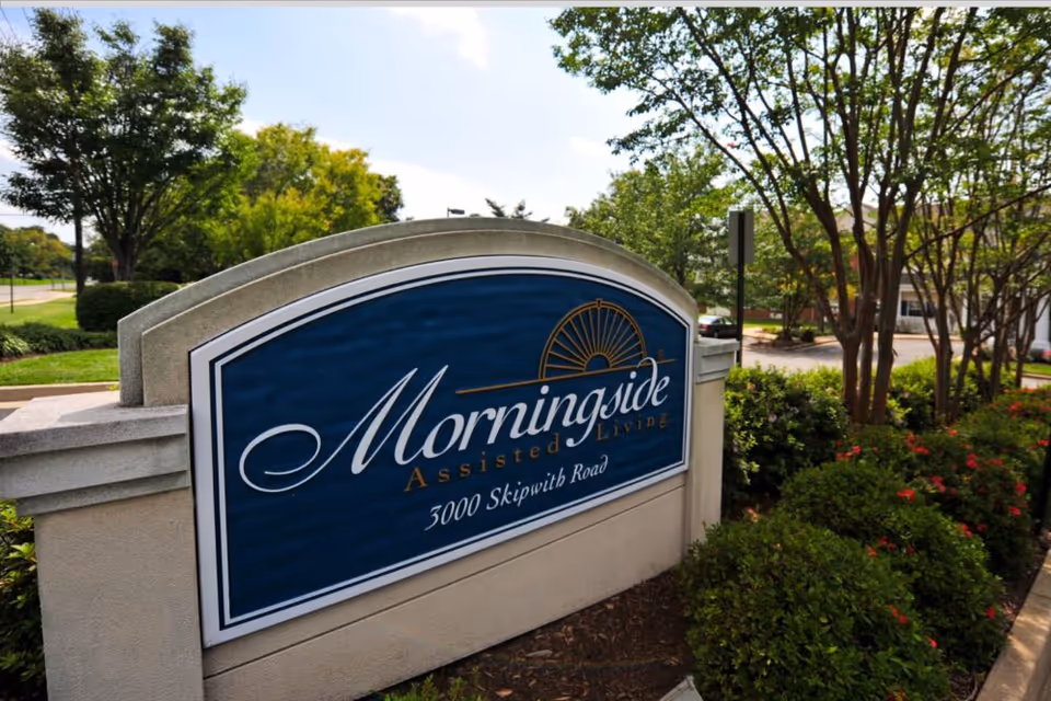 Stone entrance sign for Morningside Assisted Living (3000 Skipwith Road) surrounded by trees and shrubs.