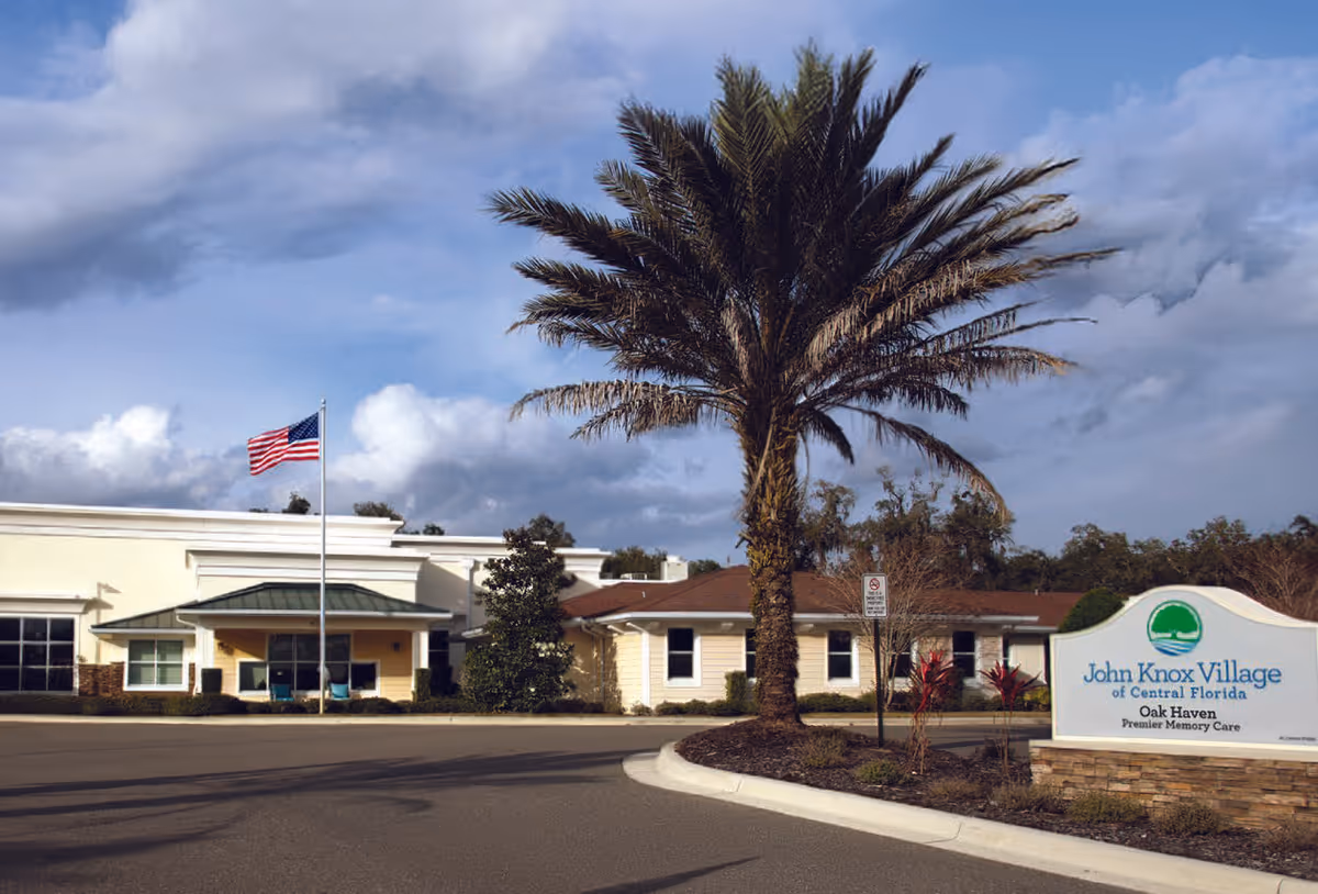 Exterior view of Oak Haven Premier Memory Care facility with palm tree and sign.