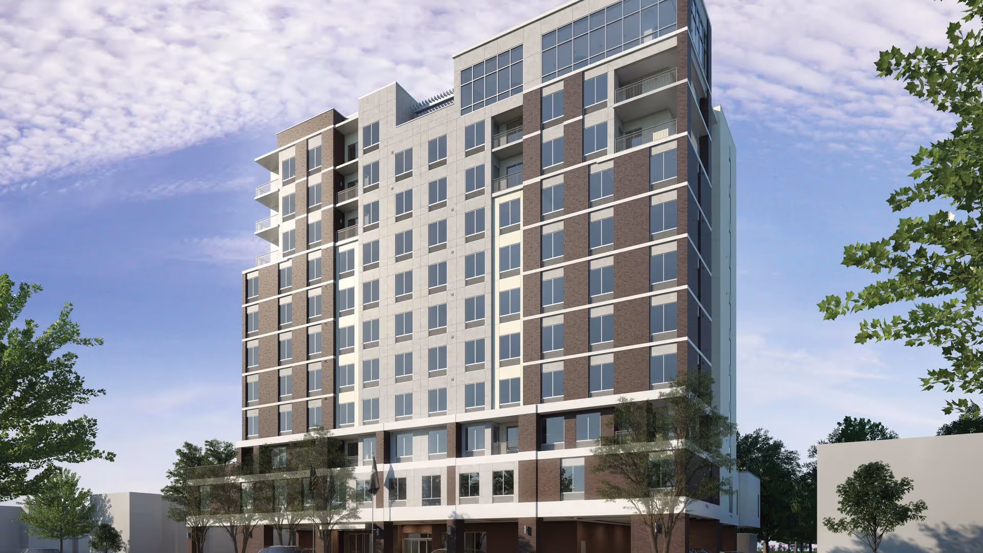 Exterior view of a multi-story senior living facility building with large windows and balconies, surrounded by trees under a partly cloudy sky.