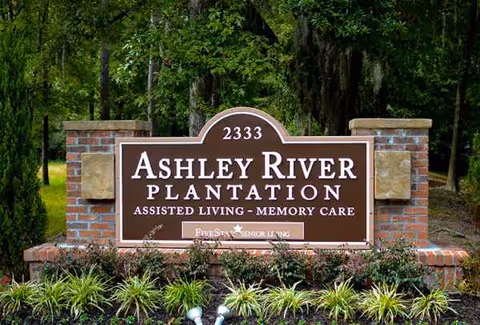 Entrance sign for Ashley River Plantation with brick pillars and landscaping.