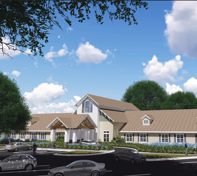 Exterior view of Indian Oaks senior living facility with a circular driveway and landscaping.
