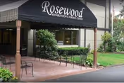 Front entrance of Rosewood Nursing and Rehabilitation Center with a covered outdoor seating area.