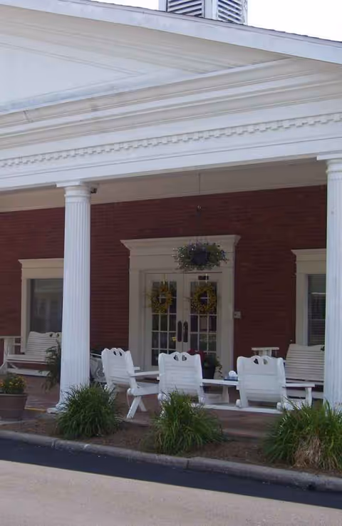 White porch seating and columns greet the Washington Nursing Center entrance.