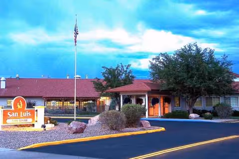Exterior view of San Luis Care Center front entrance with sign and flagpole