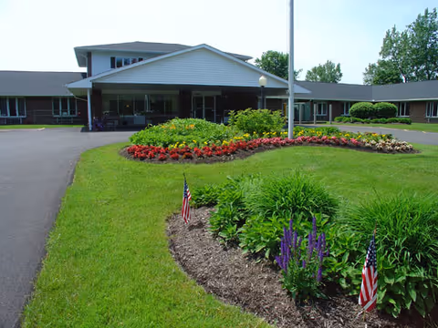 Exterior view of Elderwood Village at Bassett Park with landscaped gardens and a main entrance.