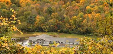 Single-story care center exterior framed by autumn trees
