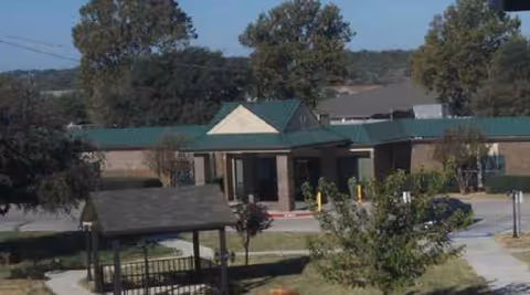 Exterior view of Brownwood Nursing & Rehabilitation facility with entrance canopy and trees.