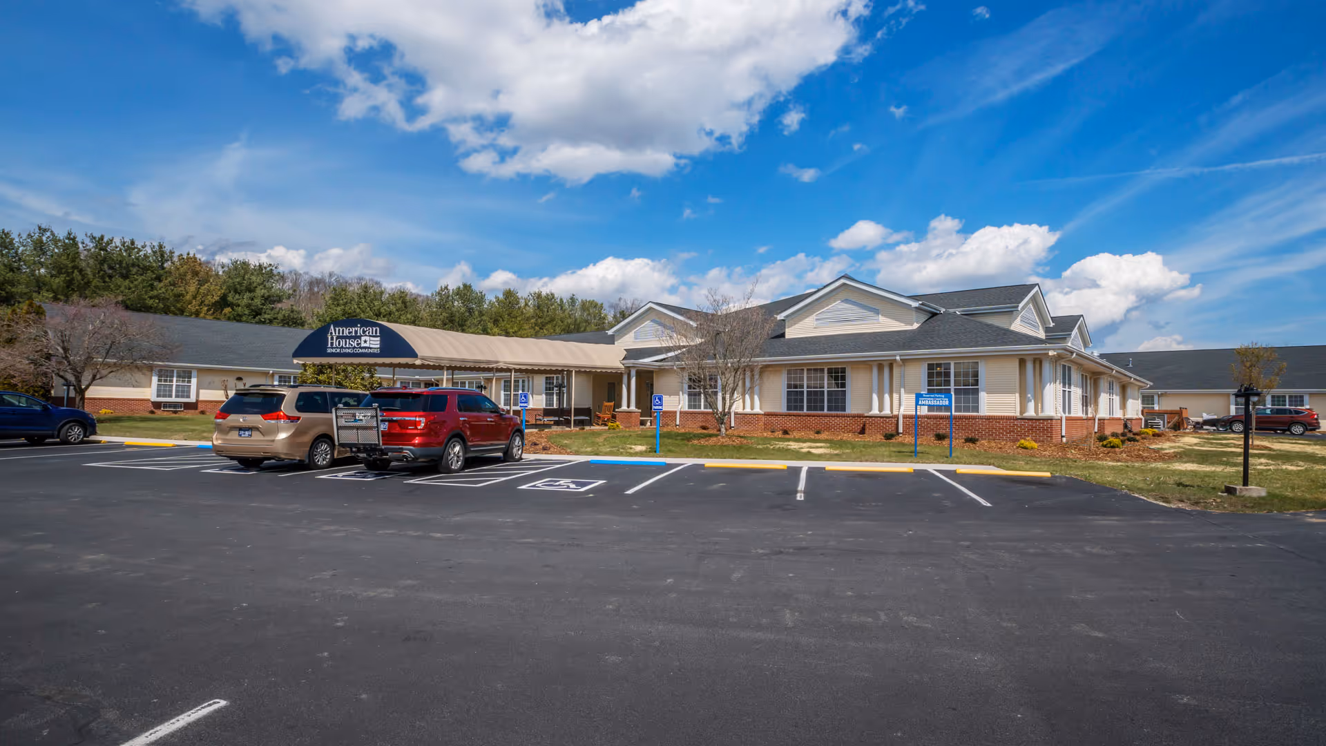 Exterior view of American House Johnson City facility with parking lot in foreground.