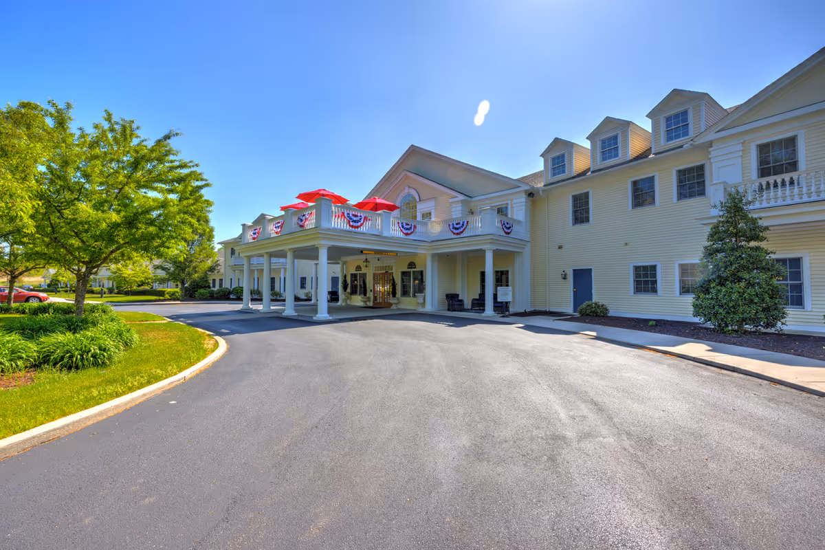 Exterior view of a senior living facility with a covered entrance and bunting on the porch.