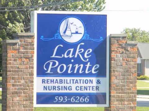Blue sign reads Lake Pointe Rehabilitation & Nursing Center between brick pillars.