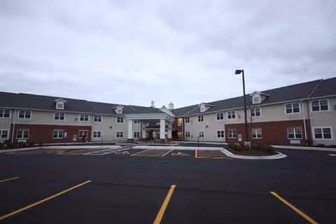 Front view of Heritage Woods of Dwight showing a two-wing building and parking lot.