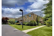 Exterior view of Spring House Estates senior living facility with stone facade and lawn