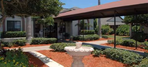 Exterior view of Grand Villa of Englewood courtyard with walkway and urn.