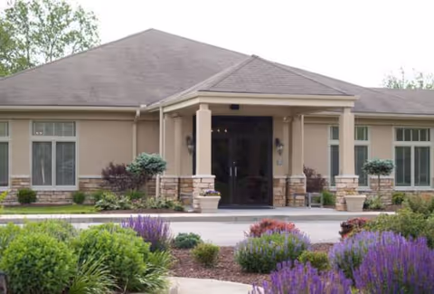 Front view of Eaton Grand Manor entrance with landscaped garden and columns.