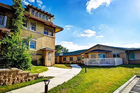Exterior view of Holton Manor showing walkway, lawn, and building entrances.
