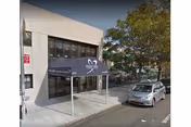 Street view of the entrance to Brooklyn Center For Rehab And Residential Health Care, showing a building with a dark blue awning over the doorway and a parked silver car on the street nearby.