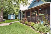 Blue single-story facility with a covered front porch and a manicured lawn.