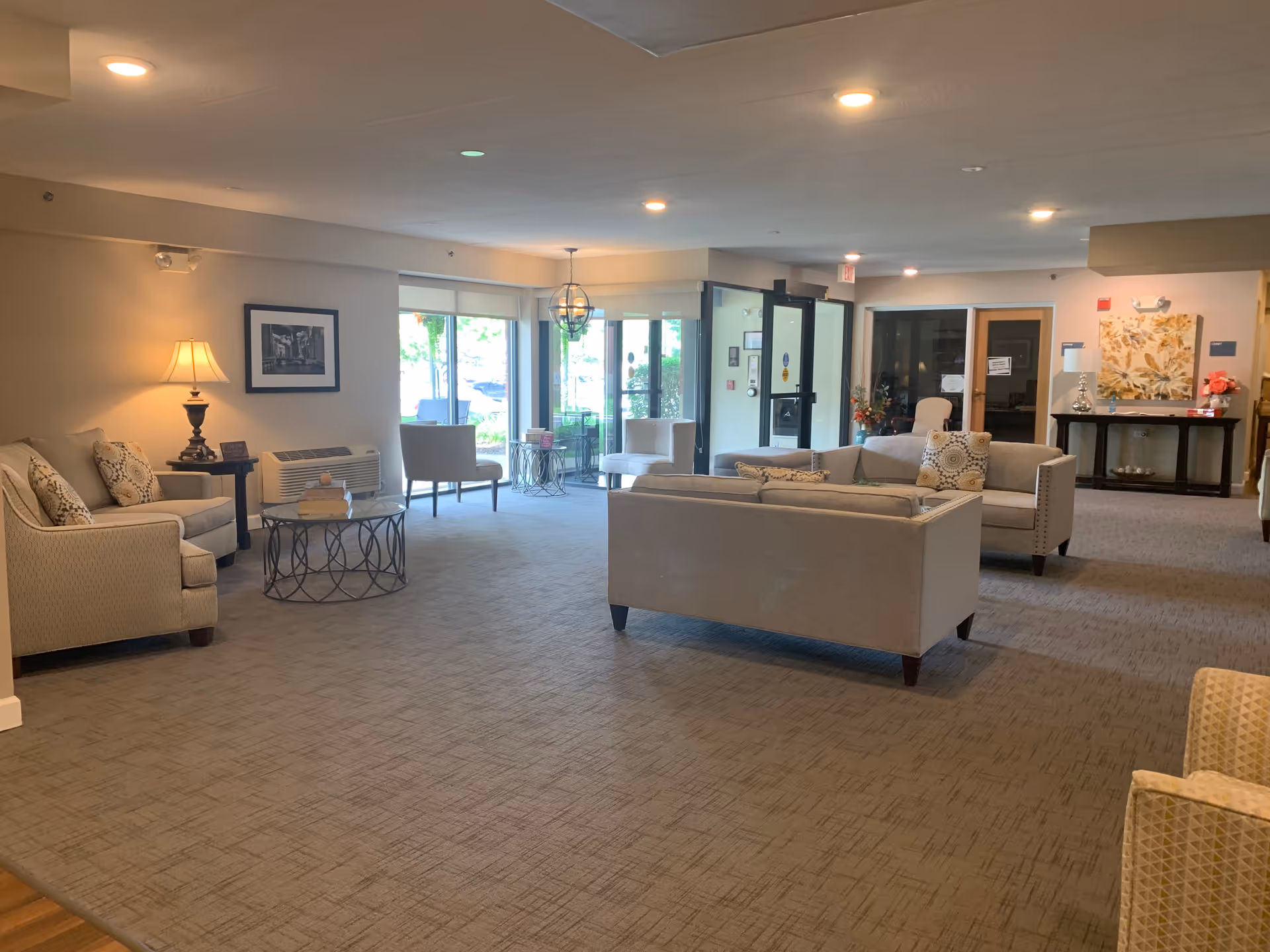Spacious furnished lobby/lounge with sofas, chairs, tables, and large windows.