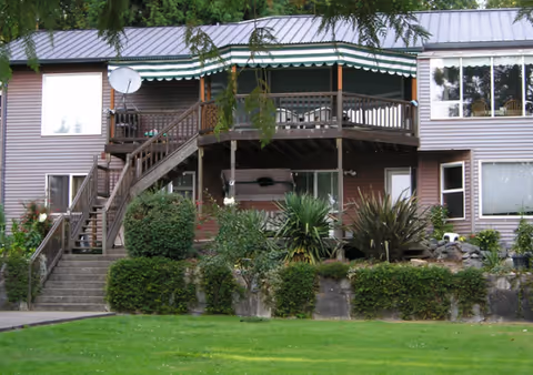 Exterior view of Star Lake AFH building with deck, stairs, and landscaped yard.