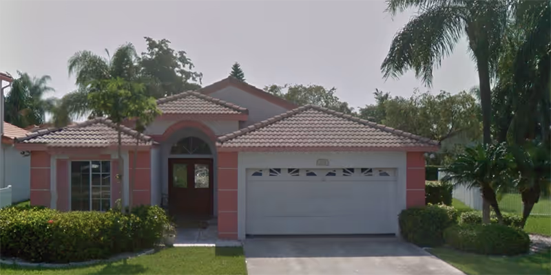 Front view of a single-story care facility with a two-car garage.