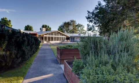 Exterior view of Avamere Health Services of Rogue Valley with walkway and landscaped planters.
