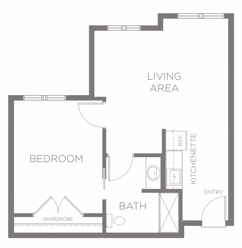 Floor plan of a living space at Sagewood at Daybreak showing a bedroom with a wardrobe, a bathroom with a shower, a living area, and a kitchenette with a refrigerator and sink near the entry.