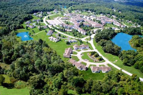 Aerial view of Laurel Lake retirement community with winding roads, buildings, and ponds.