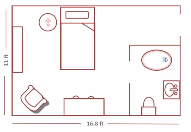 Floor plan of a small living space measuring 16.8 by 11 feet, showing a bedroom area with a bed, nightstand with lamp, and chair, along with a bathroom area containing a shower, toilet, and sink.