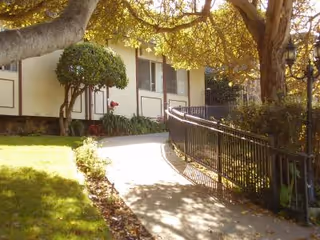 Exterior view of The Chalet Montara showing walkway, railing, and landscaped grounds.