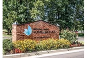 Exterior brick sign for Memphis Jewish Home & Rehab with greenery and trees.