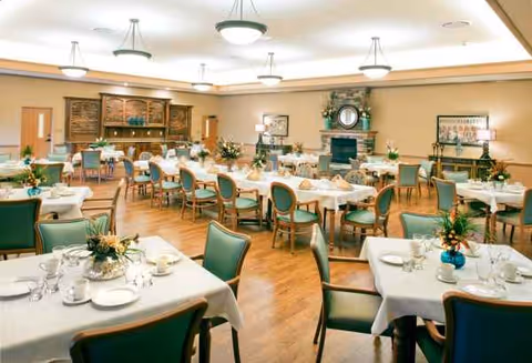 The Maples Health and Rehabilitation dining room features tables set for meals and green chairs.
