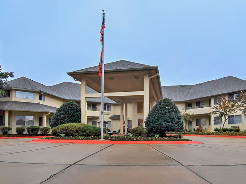 Exterior view of Holiday Andover Place showing a porte-cochère entry and flagpole.