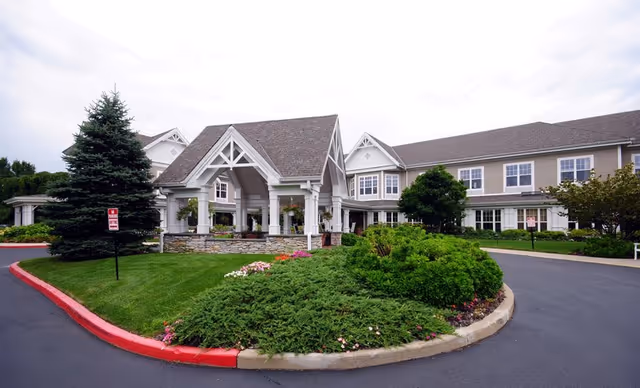 Sunrise of Holbrook facility exterior with landscaped circle driveway and welcoming entrance.