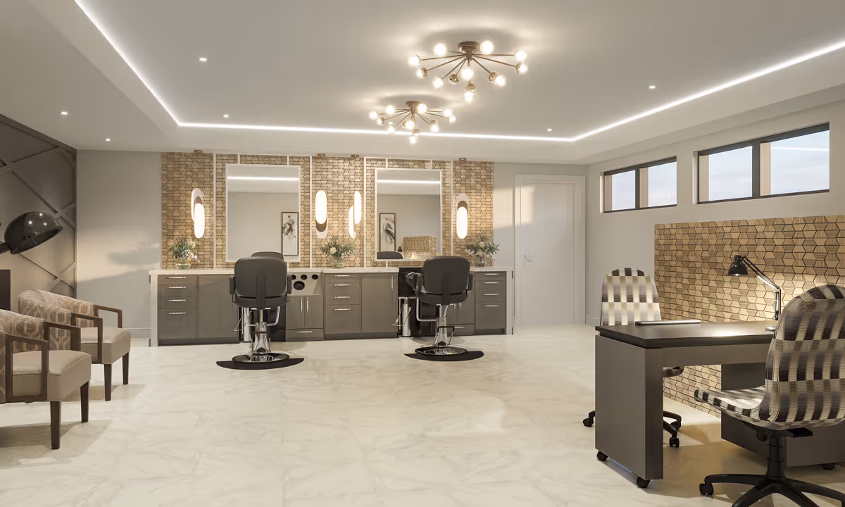 A modern salon area in a senior living facility with two styling chairs in front of large mirrors mounted on a decorative wall. There are two patterned armchairs on the left side and a desk with two checkered swivel chairs on the right. The room has bright lighting with ceiling fixtures and recessed lights, and a marble-like floor.