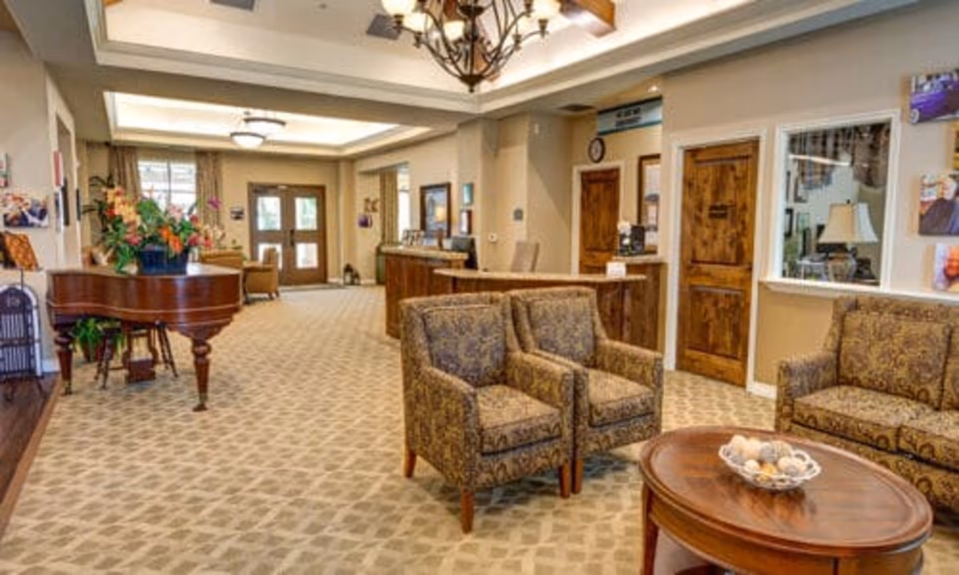 Lobby of The Auberge at Onion Creek showing a seating area with armchairs, a piano, and a reception desk.