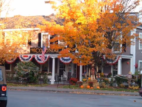 Exterior view of Newbury Court with autumn leaves, bunting, and pumpkins along the front