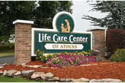 Front entrance sign for Life Care Center of Athens amid a landscaped flower bed.