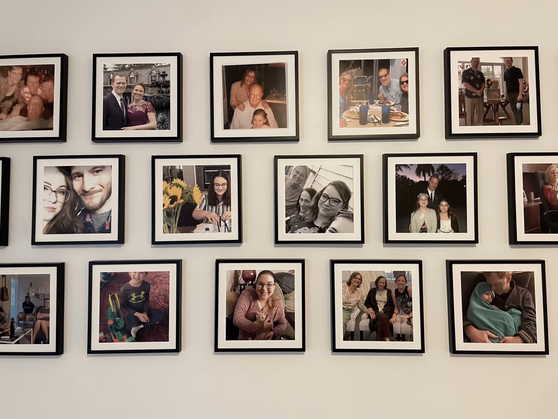 A wall display of framed family photos arranged in a neat grid.