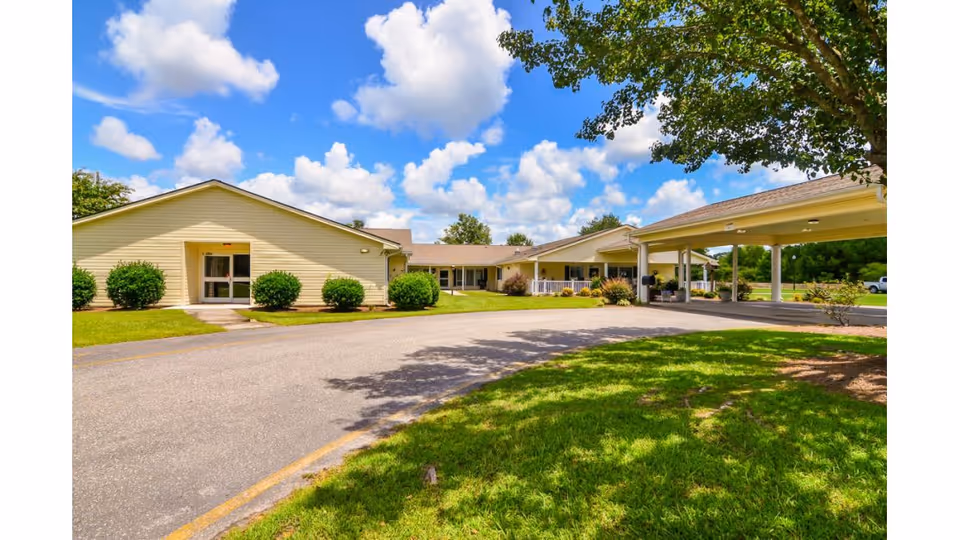 Front exterior view of Wallace Rehabilitation and Healthcare Center with driveway and green lawn.